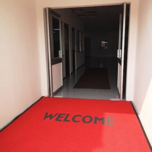 Entrance door mat in the color of red with "WELCOME" word