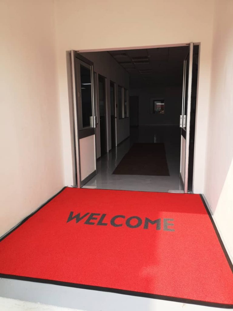 Entrance door mat in the color of red with "WELCOME" word
