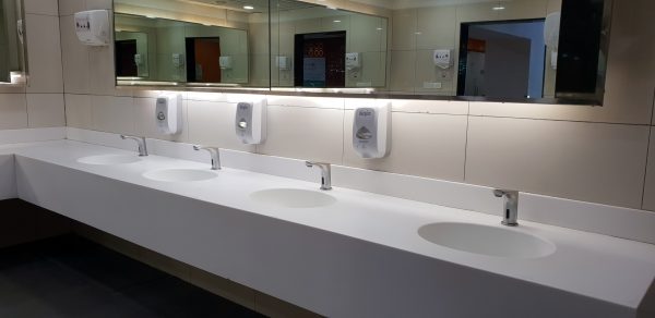A washroom with large mirrors and white basins.