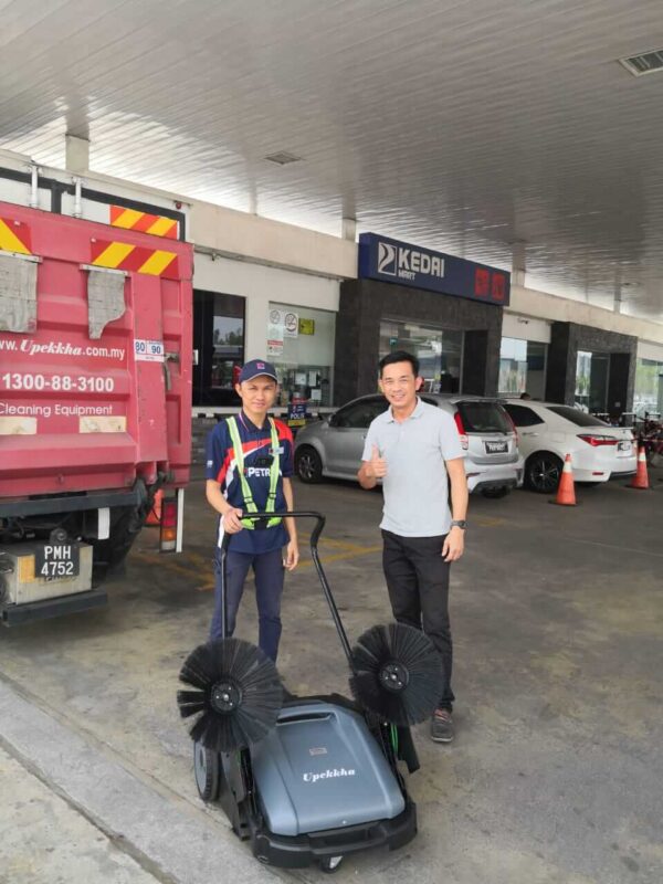 Two customers receiving their Upekkha mechanical floor sweeper machine.