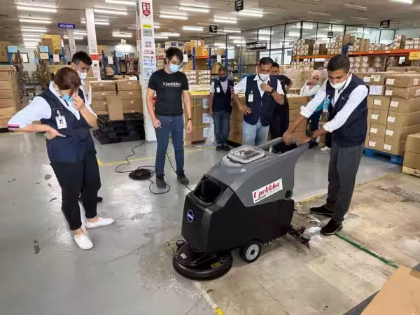 8 people with Upekkha auto scrubber floor cleaning machine.